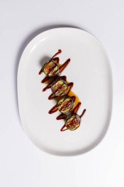 Suşi beyaz tabağın üstünde servis ediliyor.