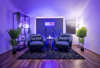 Yüksek kaliteli kayıt için profesyonel ışıklandırma ayarına sahip modern podcast stüdyosu