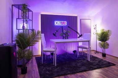 Profesyonel ışıklandırmalı modern podcast kayıt stüdyosu