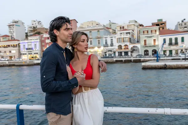 Suyun kenarında duran ve arka planda Avrupa tarzı renkli binalarla sarılan bir çember..