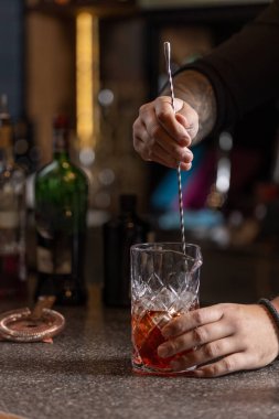 Barmen bardakta alkol kokteyli hazırlıyor.