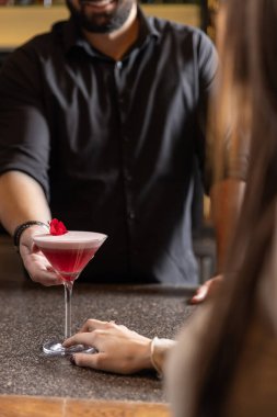 Barmen bir kıza kokteyl ikram eder.