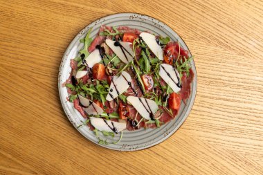 Carpaccio salatası, roka, vişneli domates ve parmesan peyniri.