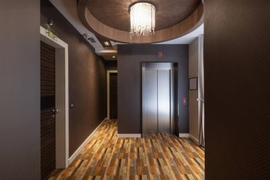 Uzun bir otel koridoru, kapı aralığı.