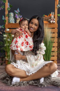 Güzel anne ve bebek yumuşak bir kürkte oturuyor.