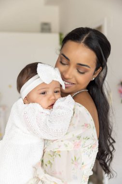 Anne ve bebek birlikte poz veriyorlar.