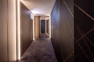 Uzun bir otel koridoru, kapı aralığı.