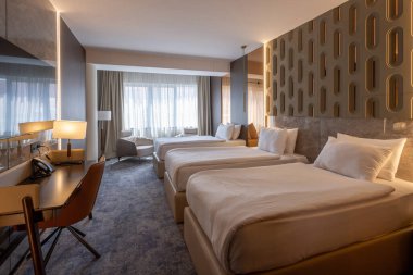 Sabah güneş ışığıyla çekilmiş üç kişilik bir otel odası.