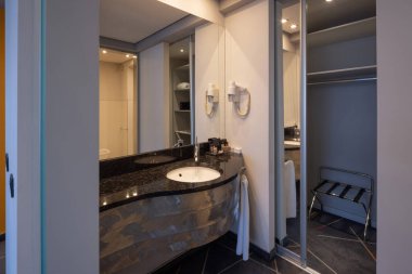 Metal endüstriyel lavabo kapağı olan bir otel banyosu.