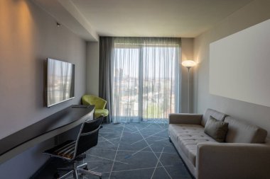 Rahat kanepeli modern bir otel odası.
