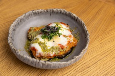 Çıtır tavuk, zengin votka sosu ve erimiş mozzarella peynirli fesleğen ve pesto.