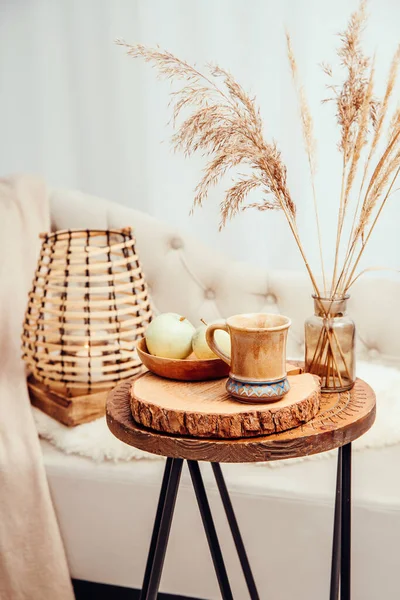 合酶或别墅概念 温暖的软棕色米色室内设计对象 舒适的毛毯在沙发上 蜡烛在木灯中燃烧 茶杯在木桌上 暖色摄影操作 — 图库照片