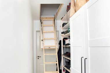 Ahşap tavan, tavan arası katlama merdivenlerini küçük minimalist koridor koridorunda, ev kavramında yer tasarrufu..