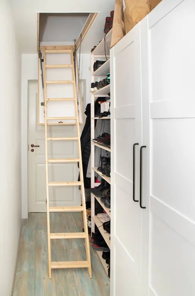 木质天花板拉下阁楼折叠式楼梯 在简约的走廊里 节省家居空间的概念 — 图库照片