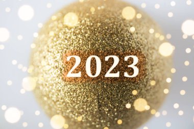 Mutlu yıllar! 2023 yılının yeni yılı. Altın rengi parıltılı Noel mücevherinin yıl numarası. İçeride, stüdyo çekimi..