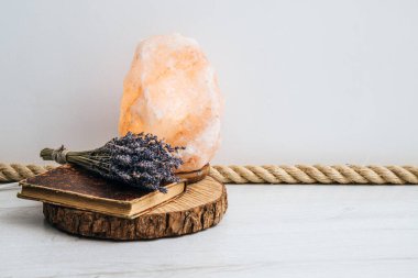 Yer süsü olarak jüt halatı kullanmak, ev tasarımı elementi. Beyaz oturma odası zemininde jute halat, ahşap disk tepsisi, antika kitap ve kurutulmuş lavanta buketi var..