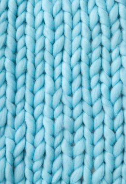 Açık mavi yumuşak yün örgü battaniye arkaplanının üzerine yakın plan.