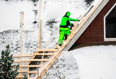 İşçiler eski çatıyı yeniden düzenliyor ya da üst üste koyuyorlar. Eski bir çatıyı kaldırmadan yeni bir çatı inşa etmek. İşçiler kışın yeni çatı için yerli ev binalarına ahşap şebeke döşüyorlar.