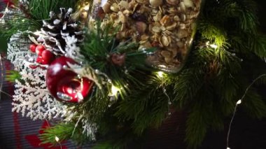 Ev yapımı Noel hediyesi kavramı, çeşitli fındıklı ve güzel cam kavanozda kuru üzümlü el yapımı granola. Bulanık Noel ağacı ve arka planda ışıklar.