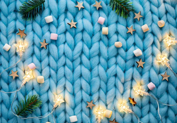 浅蓝色针织图案羊毛背景图 星形线灯 云杉树枝 小棉花糖 圣诞冬季框架 复制空间 — 图库照片