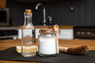 Kabartma tozu sodyum bikarbonat ve beyaz sirke kullanarak mutfak temizleme konsepti. Cam şişede beyaz sirke ve cam kavanozda kabartma tozu..