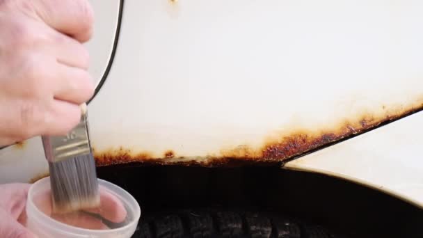 가까이 사람은 자동차의 녹슬지 부분에 자동차녹슬지 액체를 — 비디오