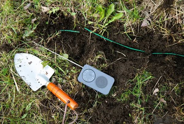 你是如何在自动割草机周边铁丝网上找到一个断裂处的 用小手持式电池操作的调幅无线电干扰信号定位断线部分 — 图库照片