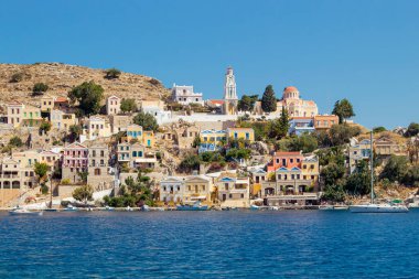 Symi, Simi olarak da bilinen Dodecanese Adaları 'ndan bir tanesidir. Güzel Symi Yialos kasabası koyda ve dağlarda güneşli yaz gününde.