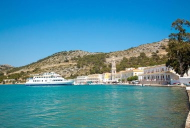 Symi, Simi olarak da bilinen Dodecanese Adaları 'ndan bir tanesidir. Yunanistan 'ın Symi adasındaki Panormitis köyü. Arka planda Taksici Michael Panormitis 'in Kutsal Manastırı.
