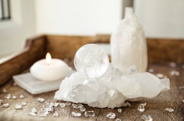 Gemstone küresi ya da kristal küre olarak bilinen kristal orbi ve orbuculum ev ortamında barış ve uyumun işaretidir. Tahta tepside kuvars jeot üzerinde doğal berrak kuvars topu.