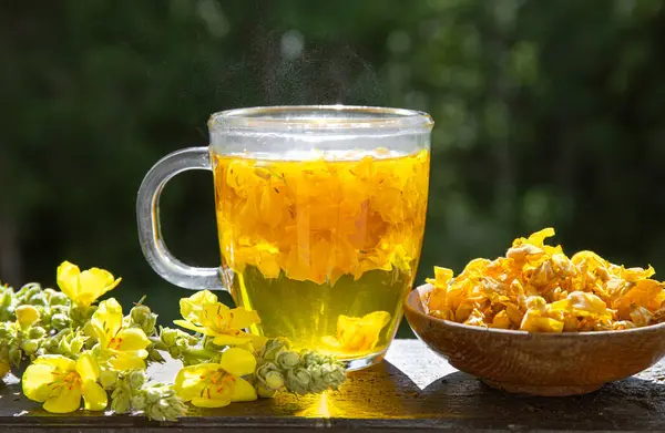 ヴェルバスカウム製のハーブ薬用紅茶ドリンク 偉大なマルライン より大きなマルラインまたは一般的なマルライン 木製ボールの黄色い乾燥茶花の花びら ストックフォト