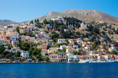 Symi, Simi olarak da bilinen Dodecanese Adaları 'ndan bir tanesidir. Güzel Symi Yialos kasabası koyda ve dağlarda güneşli yaz gününde.
