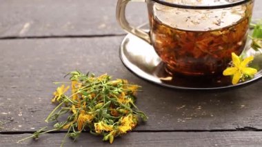Hiperikum perforatum St John 's wort olarak bilinir, St John' s wort veya yaygın St John bitki çayı beyaz ahşap arka planda cam..