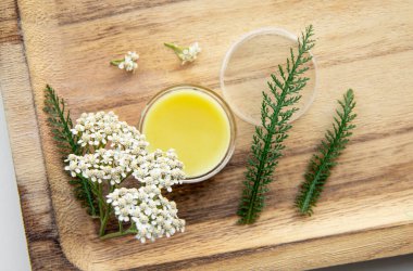 Merhem, Achillea Millefolium, kireç veya sıradan kireçten yapılır. Ahşap arka planda tıbbi merhem olan kavanoz. Dekorasyon için taze çiçek. Durgun hayat.