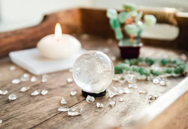 stock image Gemstone crystal sphere or crystal balls known as crystallum orbis and orbuculum which is the beacon of peace and harmony in home environment. Natural clear quartz ball on stand on wood tray in home.