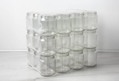 A pile of empty clean packed glass jars on top of each other. In room, white background. clipart