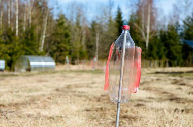 Kesilmiş bıçaklarla çevrili boş bir plastik şişe. Titreşimler ve çıngıraklı yılanlar bahçede, köstebekleri ve tarla farelerini korkutup kaçırıyor. Sahada ev yapımı yel değirmenine odaklan.