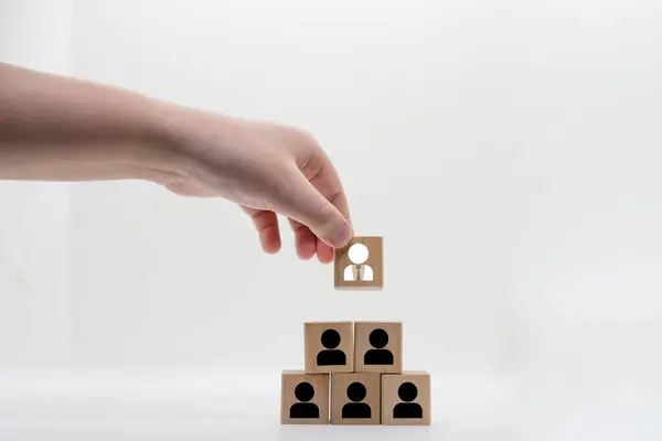 hand pick employee in team on wood blocks icon in human resource searching for right man in company teamwork group concept