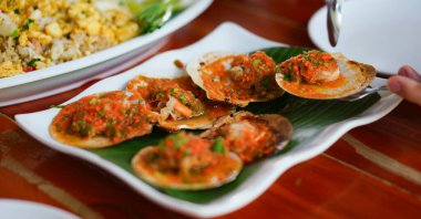 Deniz ürünleri masasında sarımsaklı deniz tarakları.