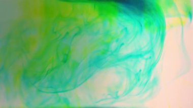 mavi ve sarı renkli boya mürekkep suyu yavaş çekimde düşer.