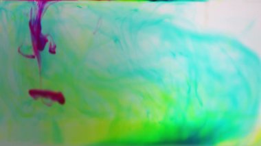 mavi mor ve sarı renkli boya mürekkebi yavaş çekimde suya düşer.