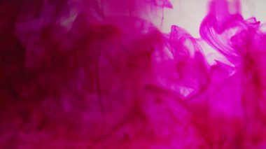 Mor renkli bulanık dalgalı boya mürekkebi yavaş çekimde suya düşer.