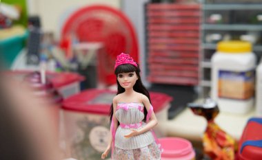 Barbie bebek askısız bir gece elbisesi giyer ve taç giyer. Çocuk oyuncakları. Bulanık çocuk başı ön planı                               