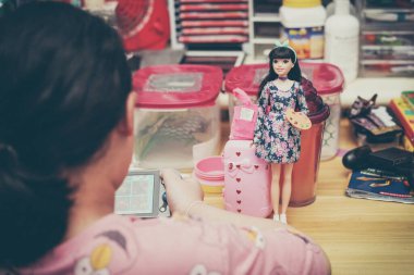 Barbeküyle oynayan kız özel dikim kıyafetler giyiyor.