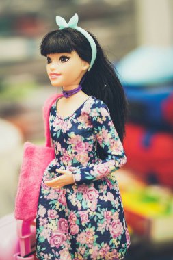 Barbeküyle oynayan kız özel dikim kıyafetler giyiyor.