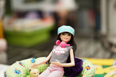 Barbeküyle oynayan kız özel dikim kıyafetler giyiyor.