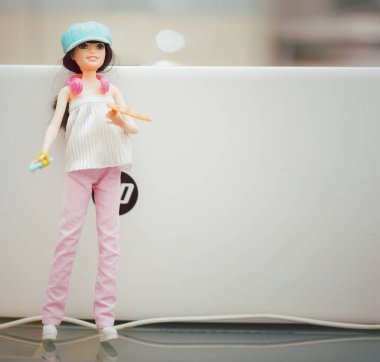 Barbeküyle oynayan kız özel dikim kıyafetler giyiyor.