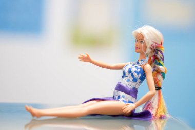 Oyuncak bebek kostümlü oturuyor.