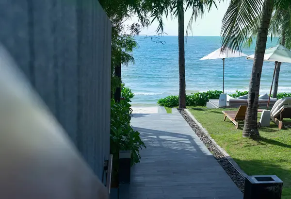 Otelin ve gökyüzünün önünde kumsala yürü.