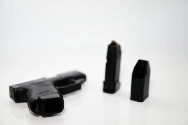 Tabanca şarjörünün tabancası ve bulanık mermi şarjörü yükleyici seçici odak beyaz yüksek açılı görünüm ve boşluk kopyala